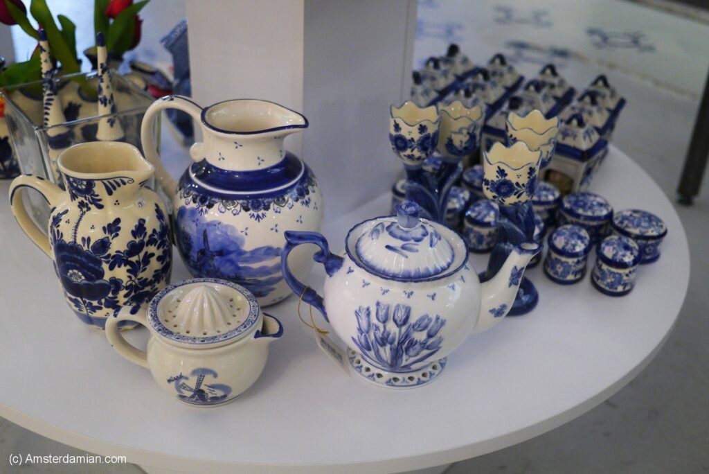 A display of traditional Dutch blue-and-white ceramics, including teapots and cups, arranged on a white table