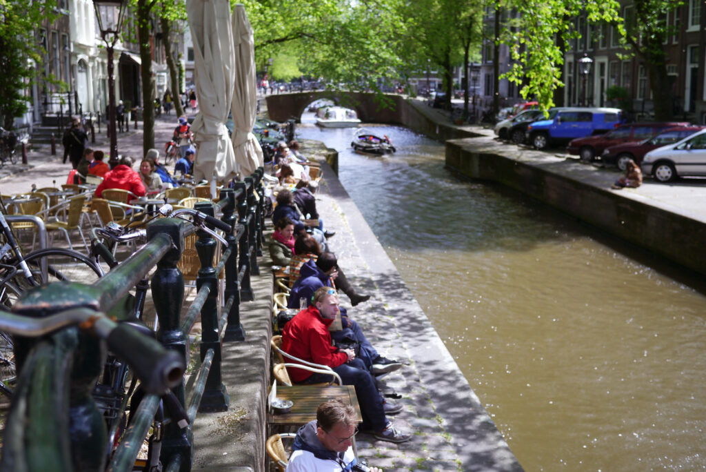 People enjoying the sun next to the canal at the Spanjer