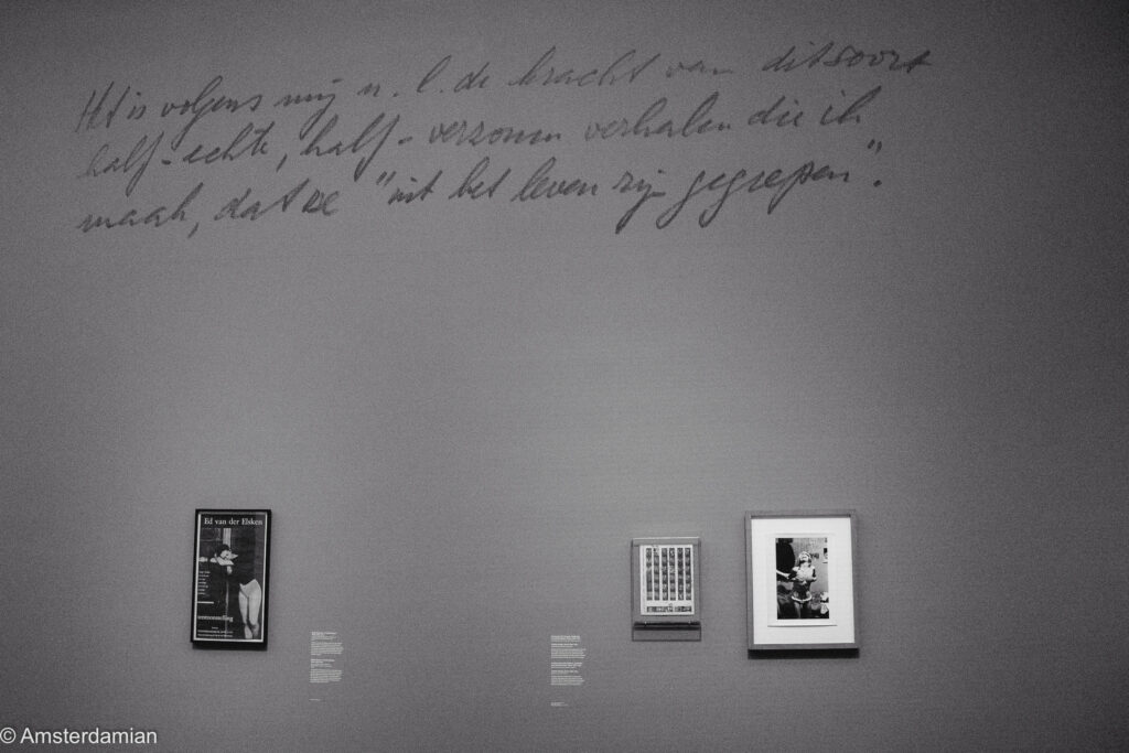 A gallery wall with a large handwritten Dutch quotation above an Ed van der Elsken book poster and two framed photographs.