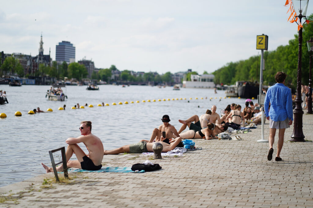 People sunbathing on the Amstel River on Weesperzijde Amsterdam