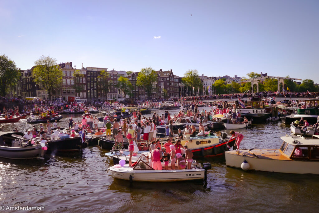Dozens of small boats filling the Amstel near the Magere Brug during Pride