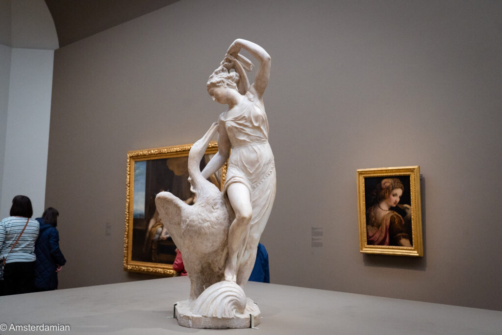 Marble statue of Leda with the swan, flanked by old master paintings
