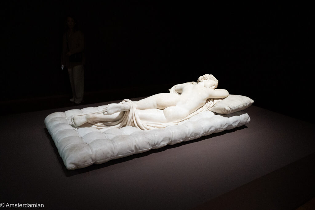 The Sleeping Hermaphroditus lying on Bernini's marble mattress, spotlit in a dark room