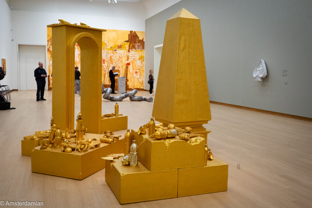Gold-painted obelisk, arch and scattered gilded objects by John Miller at the Stedelijk