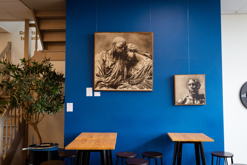 Two sepia portraits on a blue café wall