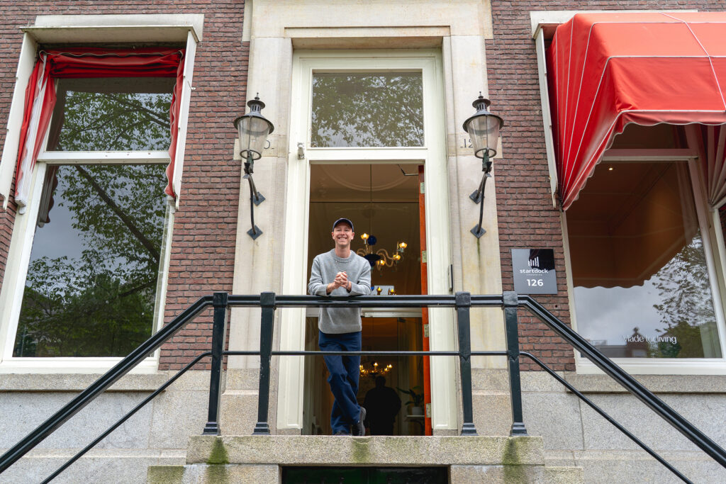 Jasha Berkenbosch at the entrance of Startdock, an Amsterdam canal house