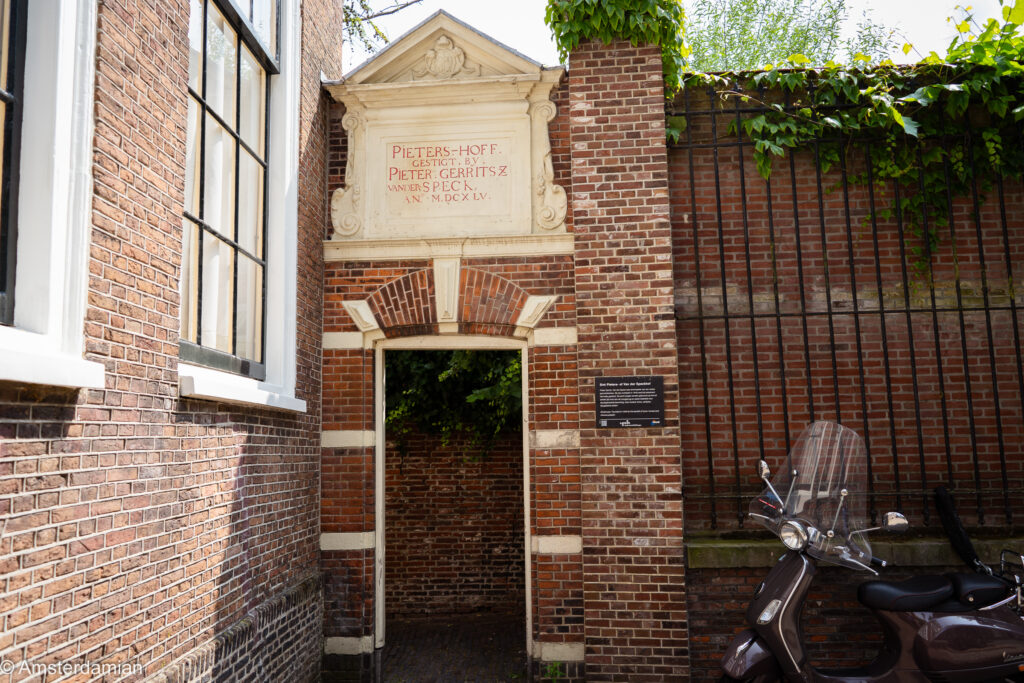 Brick gateway with a carved 1655 inscription leading into a historic Leiden hofje, or almshouse