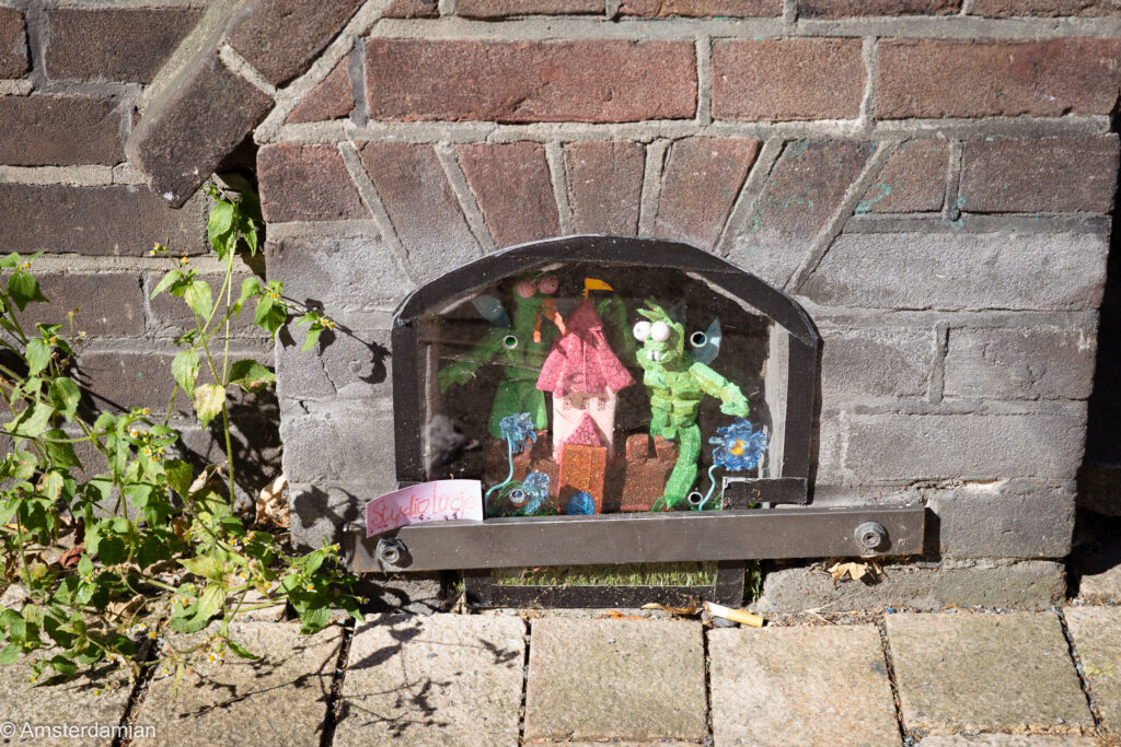 Tiny diorama with handmade figures set into a shoe scrapper place in Tilburg
