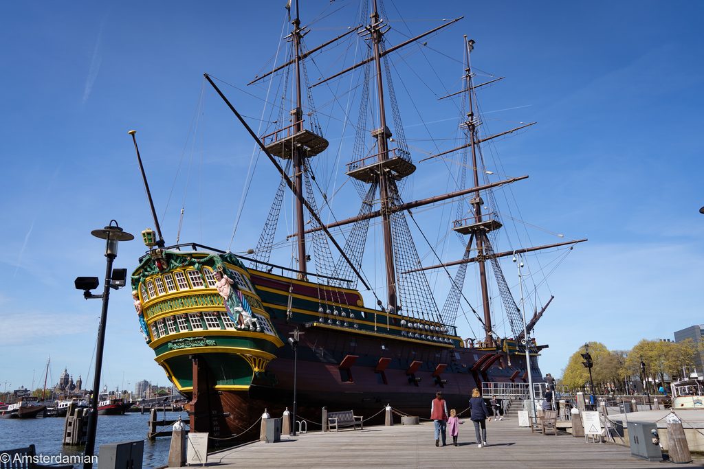The replica VOC ship Amsterdam moored outside Het Scheepvaartmuseum under a clear blue sky