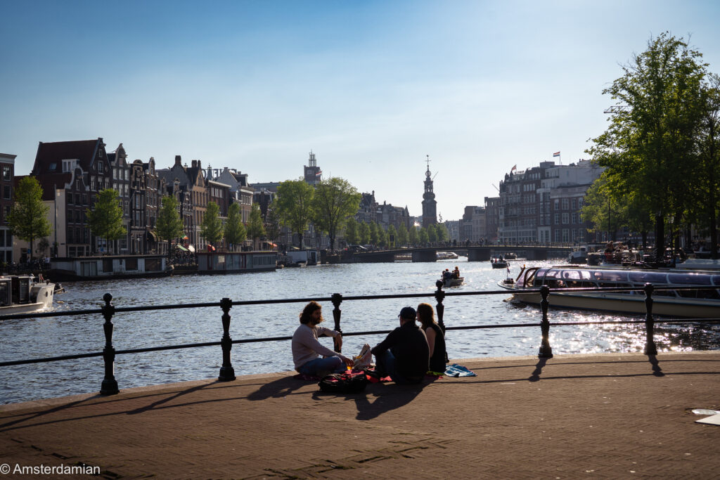 People sitting near water at the Spinoza corner