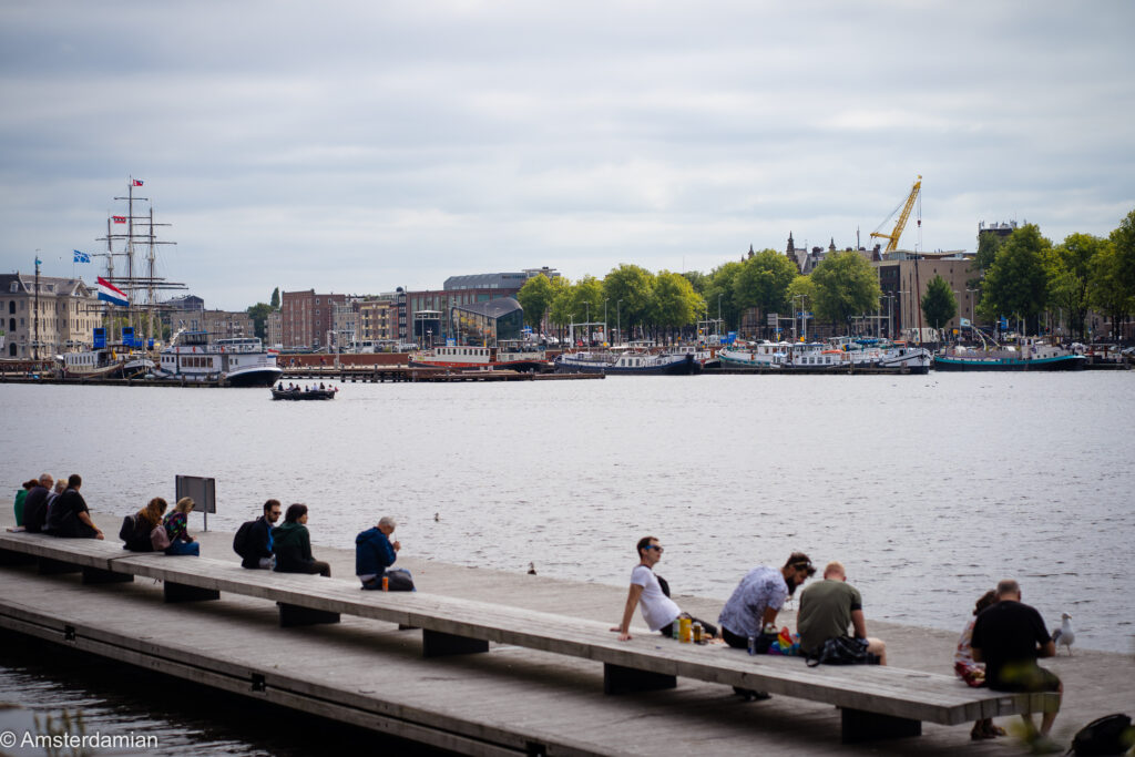 People sitting on the pier in front of OBA