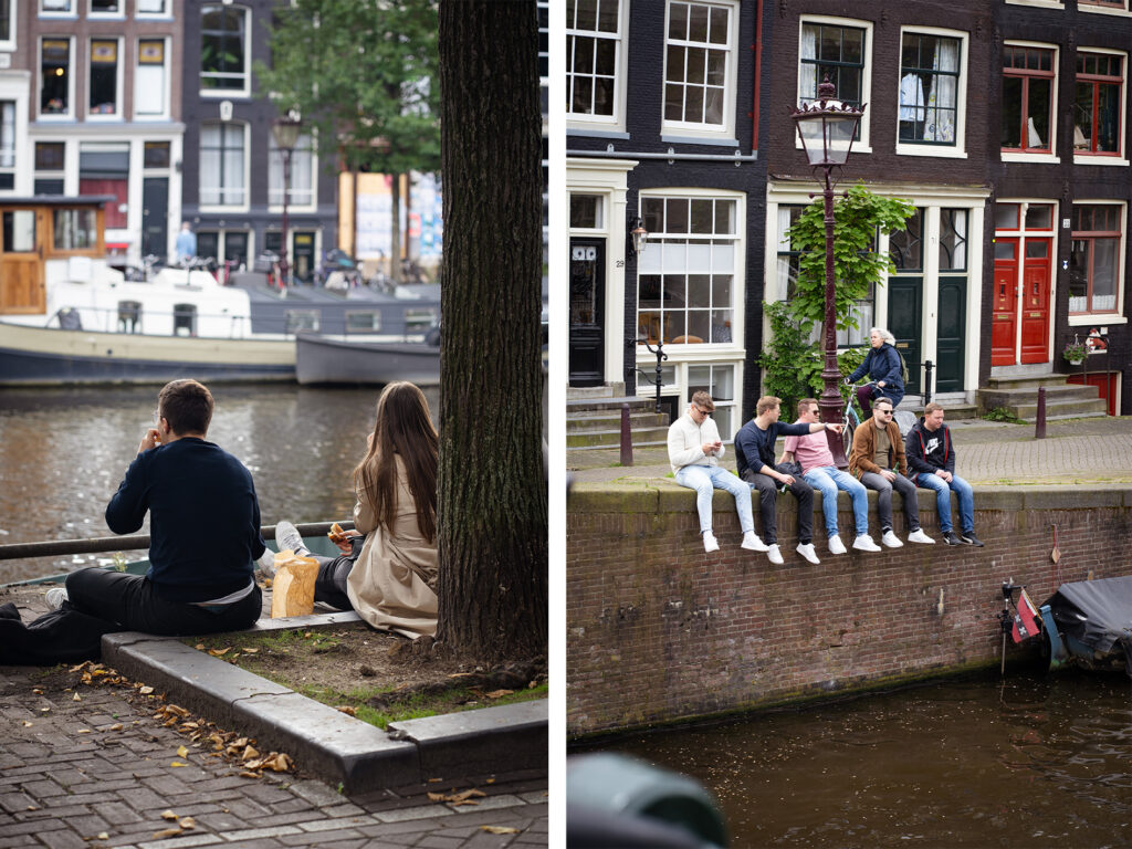 People sitting on a canal's edge in Amsterdam