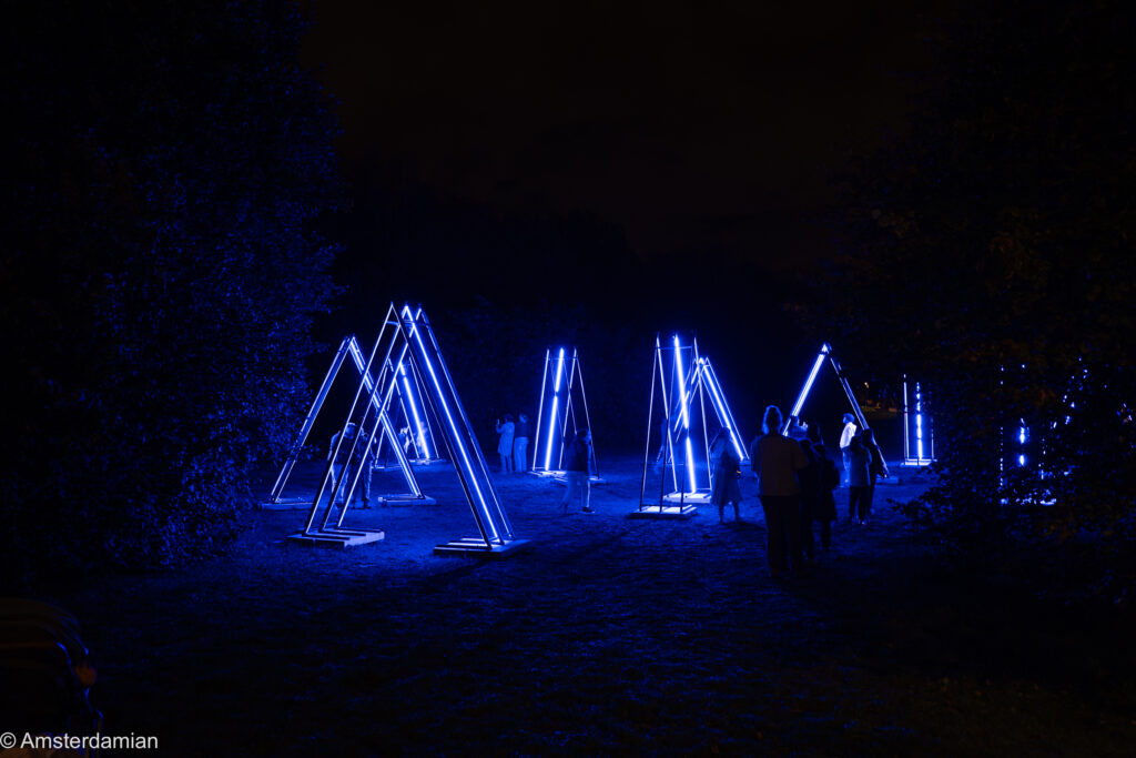 Blue neon triangle installation at the ALLUMINOUS light art festival, Almere