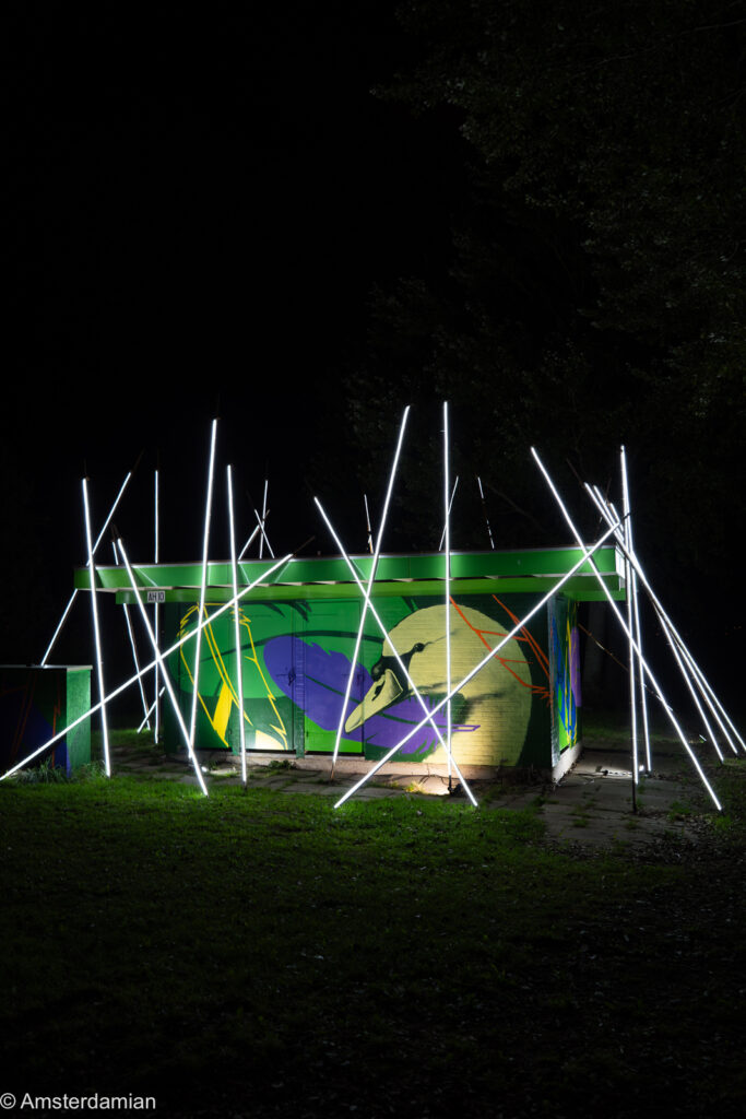 White light tubes around a painted shelter at the ALLUMINOUS festival