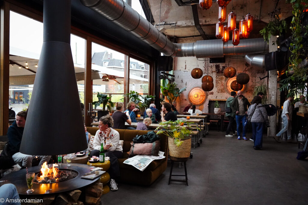 Fireplace and diners inside Foodhall MOUT on the Marktplein in Hilversum