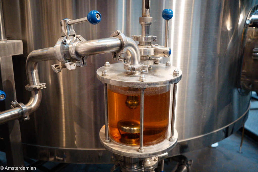Close-up of beer in a sight glass on a brewing tank in Hilversum