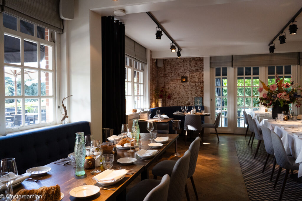 Dining room with set tables and a brick wall at The WineKitchen at Sea