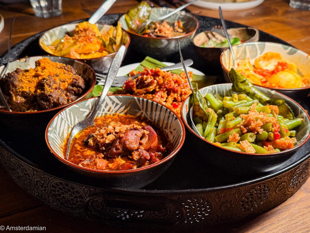 Indonesian rijsttafel with small bowls of dishes at Indo Kitchen Bar, Almere